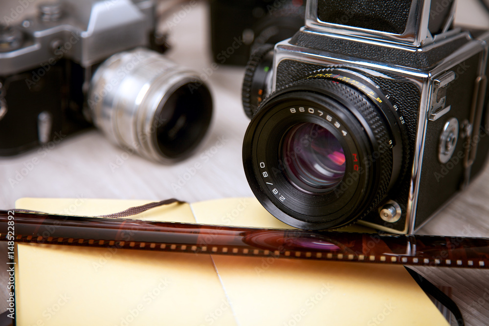 Vintage professional photo film cameras, notepad, filmstrip.