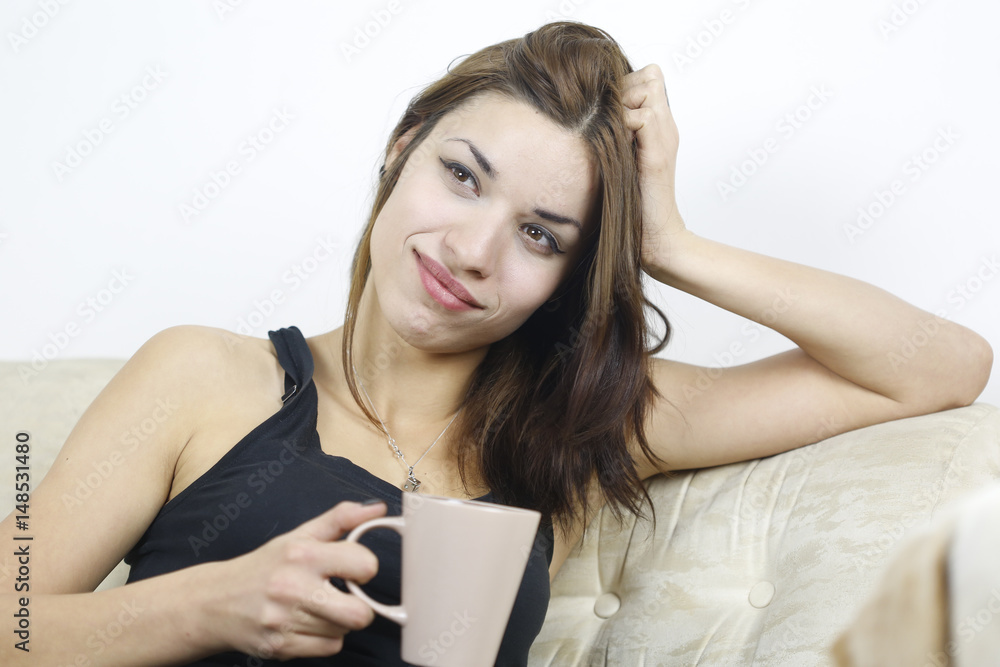 Young attractive woman drinking coffee on sofa and smiling Young attractive woman drinking coffee on sofa and smiling