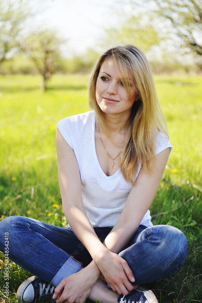 A blonde is resting in the park in the spring. A blonde is resting in the park in the spring.