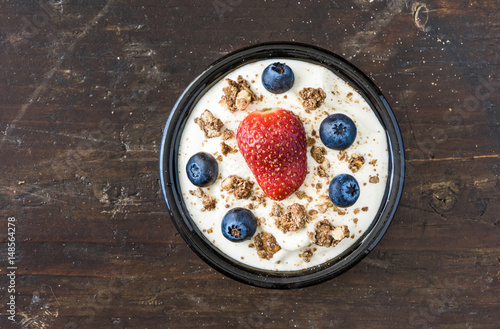 Bowl of Yogurt with Berries and Muesli on Wooden Background, Top View
