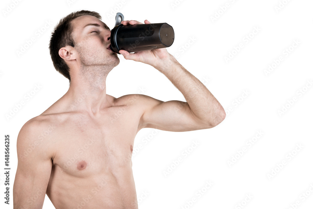 Healthy lifestyle and fitness. Handsome guy sports a physique, with a naked body, drinks water from a bottle, isolated on a white background. Horizontal frame Healthy lifestyle and fitness. Handsome guy sports a physique, with a naked body, drinks water from a bottle, isolated on a white background. Horizontal frame