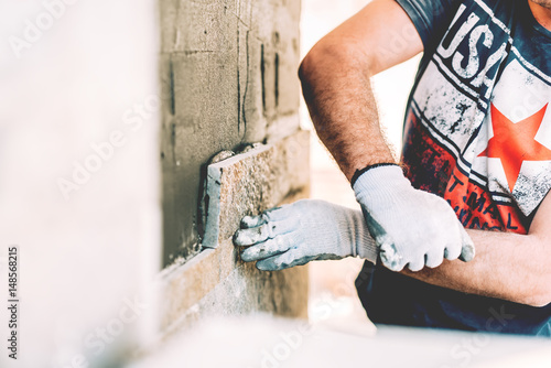 Fotografie Construction worker mason building a house and paving with stone