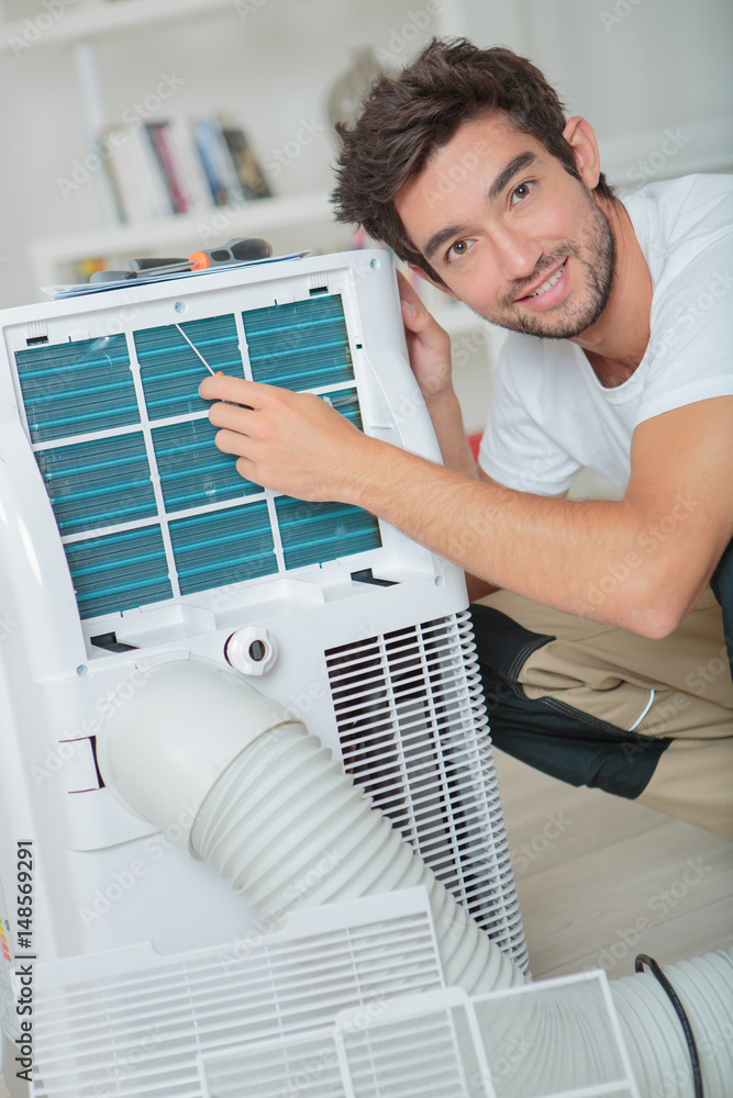 Portrait of man working on air conditioning unit Stock Photo | Adobe Stock