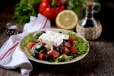Classic Greek salad from tomatoes, cucumbers, red pepper, onion with olives, oregano and feta cheese.