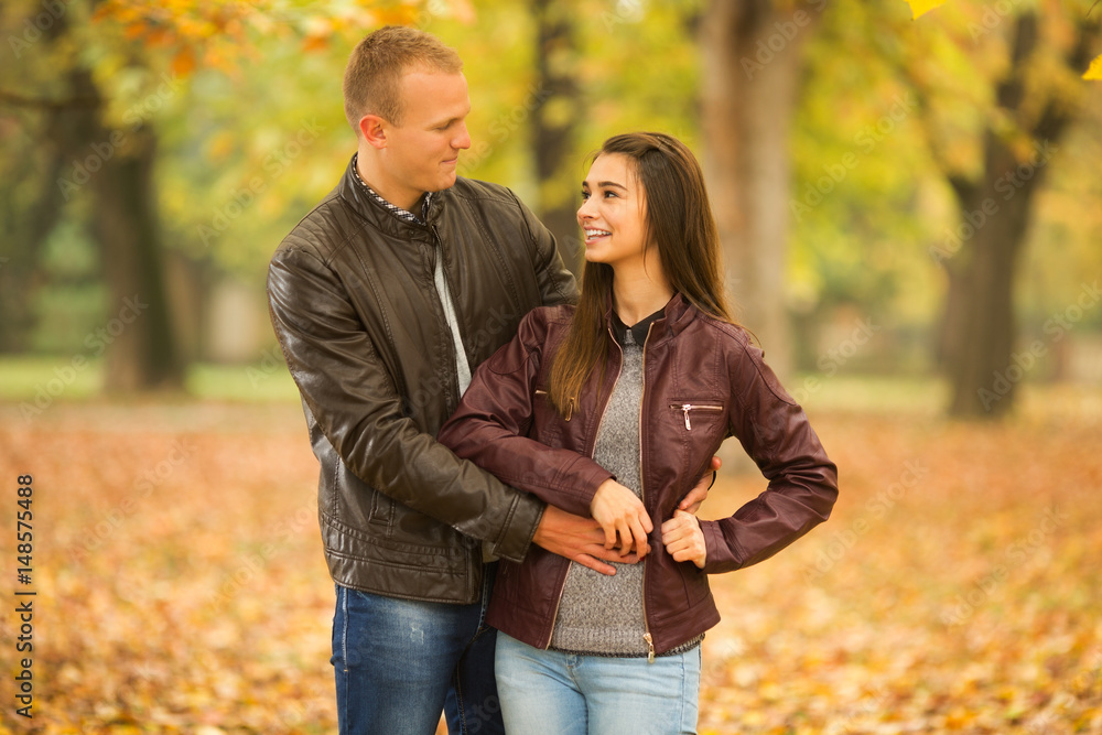Fototapeta premium Young couple in love looking each other in a park