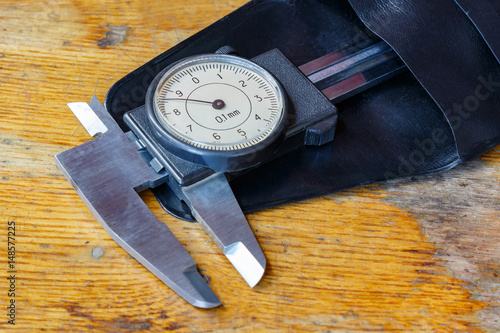 Slide caliper with a round dial in a storage case