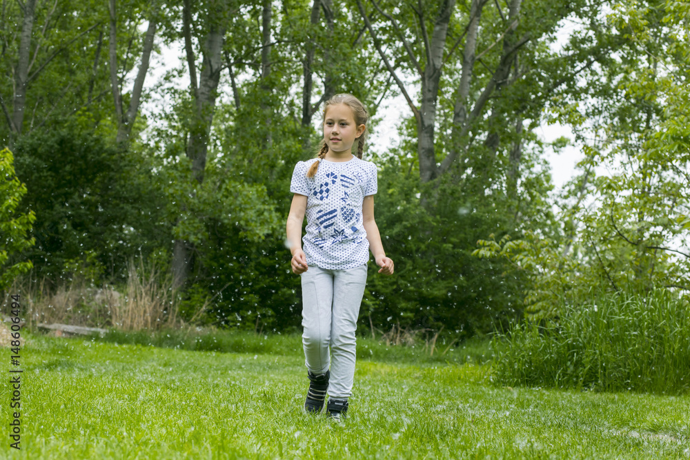 Little girl playing with poplar fluff on the green park outdoor. Little girl playing with poplar fluff on the green park outdoor.