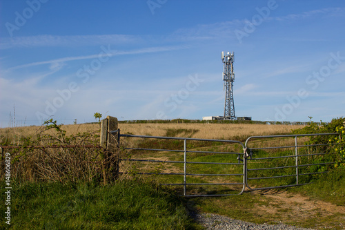 A typical radio and mobile phone network telecommunications tower situate in farmland near Groomsport in County Down, Northern Ireland makes an impressive site against a clear blue sky.