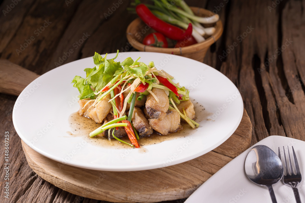 Piece of fried King Mackerel fish with fish sauce, served with spicy seafood sauce, thai style Piece of fried King Mackerel fish with fish sauce, served with spicy seafood sauce, thai style