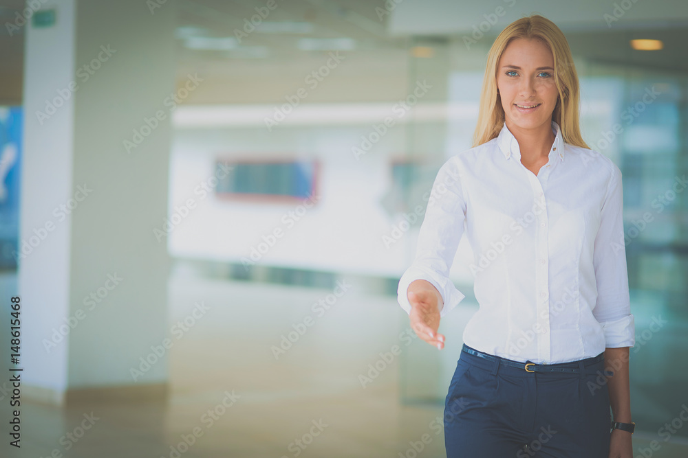 Young business woman ready to handshake standing in office Young business woman ready to handshake standing in office