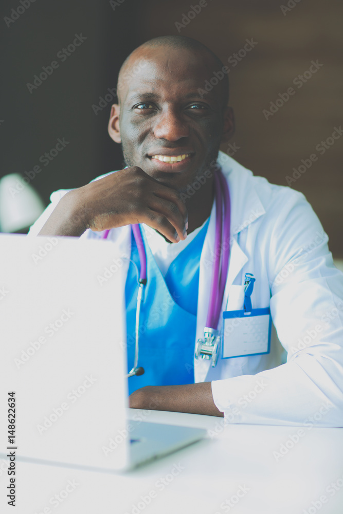 Young african doctor working on laptop at desk Young african doctor working on laptop at desk