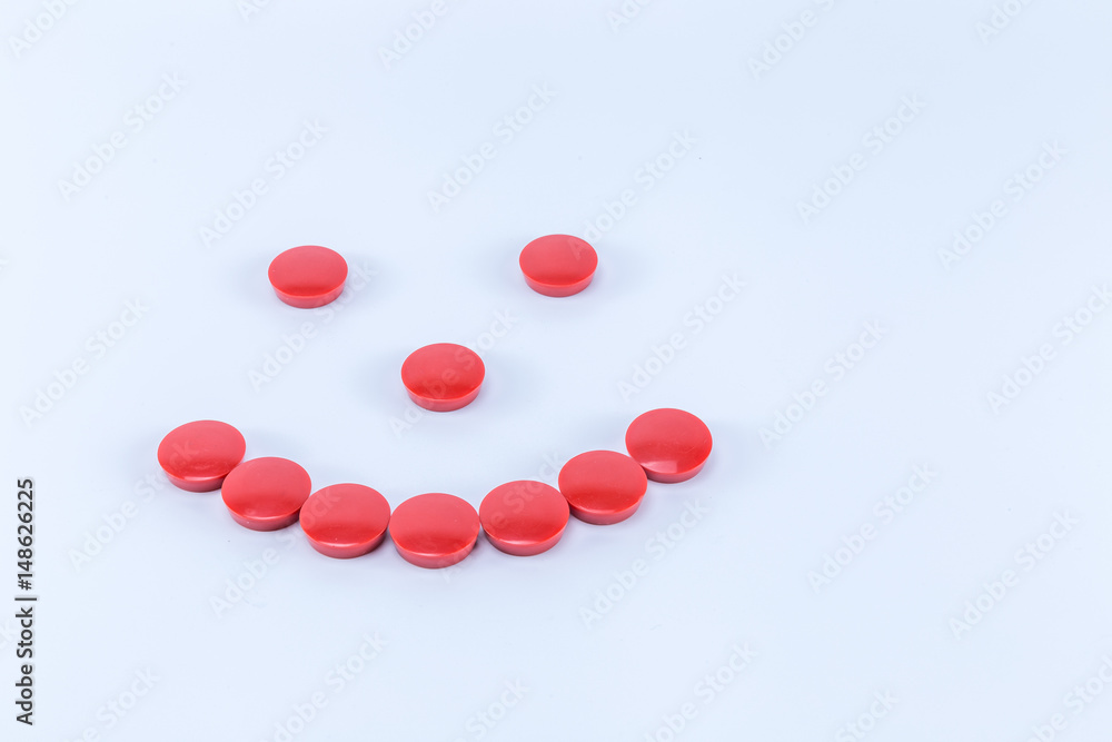 Smile face made of red round magnets isolated on white background Smile face made of red round magnets isolated on white background