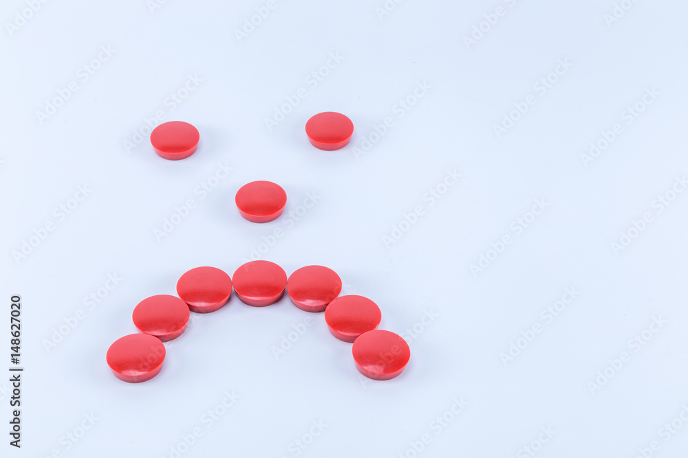 Sad face made of red round magnets isolated on white background Sad face made of red round magnets isolated on white background