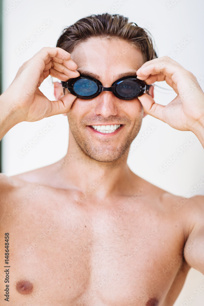 Young handsome sportsman in googles getting ready for a swim Young handsome sportsman in googles getting ready for a swim