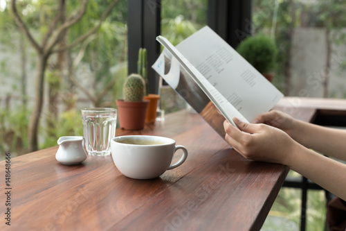Asian people reading book and fresh cup of coffee