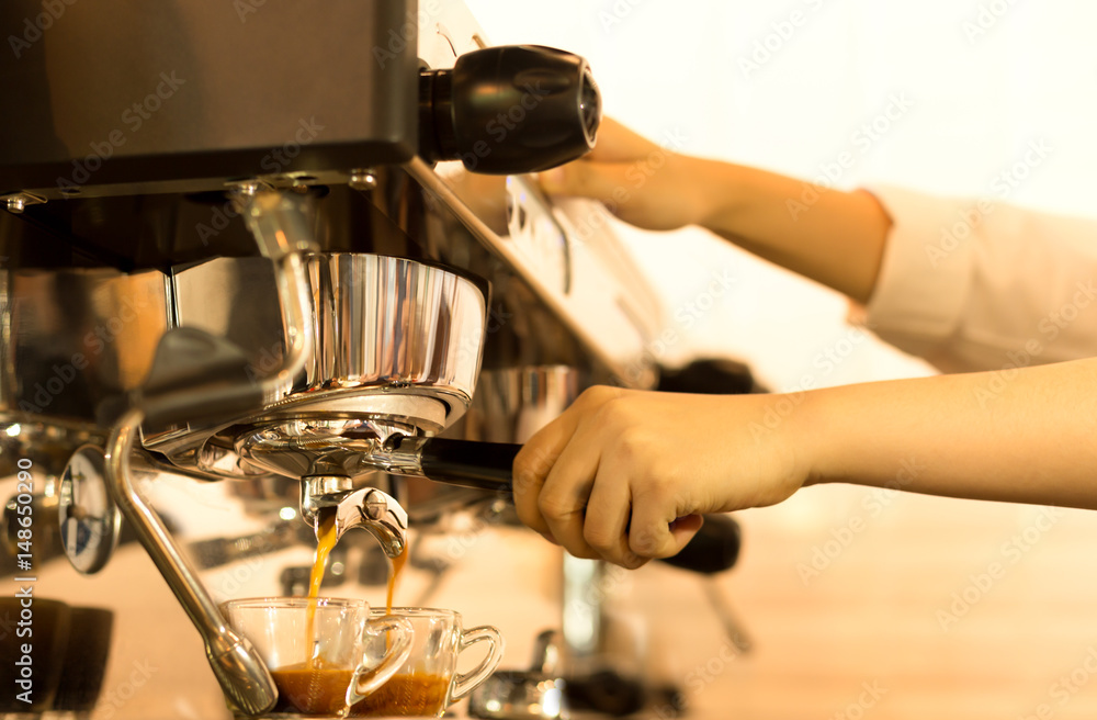 Barista making fresh espresso from coffee machine