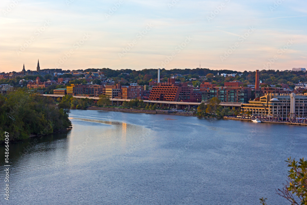 Obraz premium Georgetown Park along the river at sunset. Potomac River waterfront buildings in the evening.