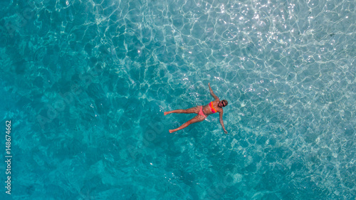 Aerial photo of girl in blue water of Indian ocean