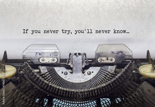 Vintage typewriter on white background with text If you never try, you'll never know.