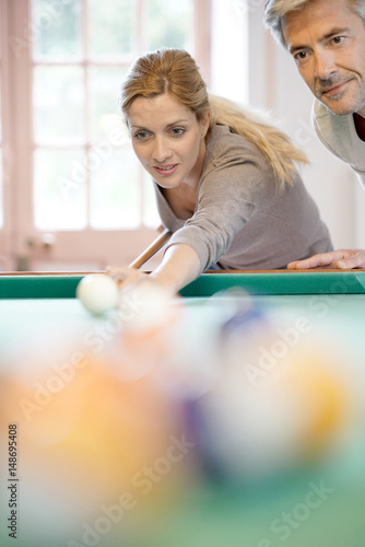mature couple playing pool together