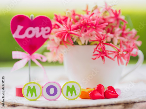 mother's day concept. LOVE MOM alphabet with colorful heart and flower on background