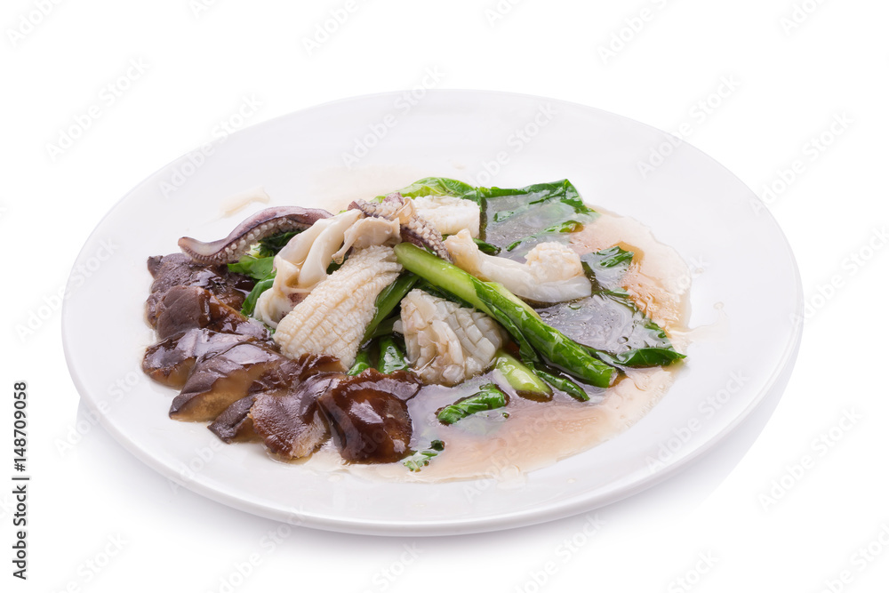 Stir fried kale with fresh squid on white dish Stir fried kale with fresh squid on white dish