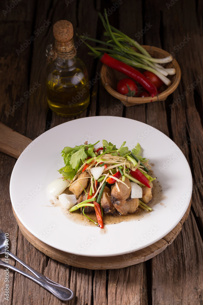 Piece of fried King Mackerel fish with fish sauce, served with spicy seafood sauce, thai style Piece of fried King Mackerel fish with fish sauce, served with spicy seafood sauce, thai style