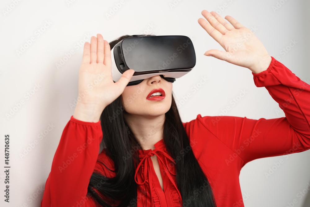 frau trägt eine vr brille und hält abwehrend die hände nach oben frau trägt eine vr brille und hält abwehrend die hände nach oben