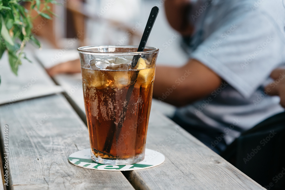 Refreshing glass of cola on wooden table in a bar