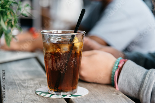 Canvas Print Refreshing glass of cola on wooden table in a bar