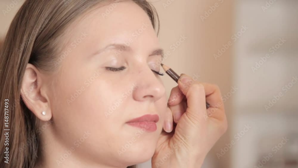 make-up artist drawing eyebrows of client by pencil. Close up shot. make-up artist drawing eyebrows of client by pencil. Close up shot.