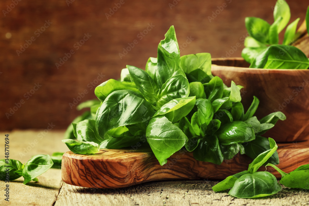 Fresh green basil in olive mortar with pestle, vintage wooden background, rustic style, selective focus - obrazy, fototapety, plakaty 