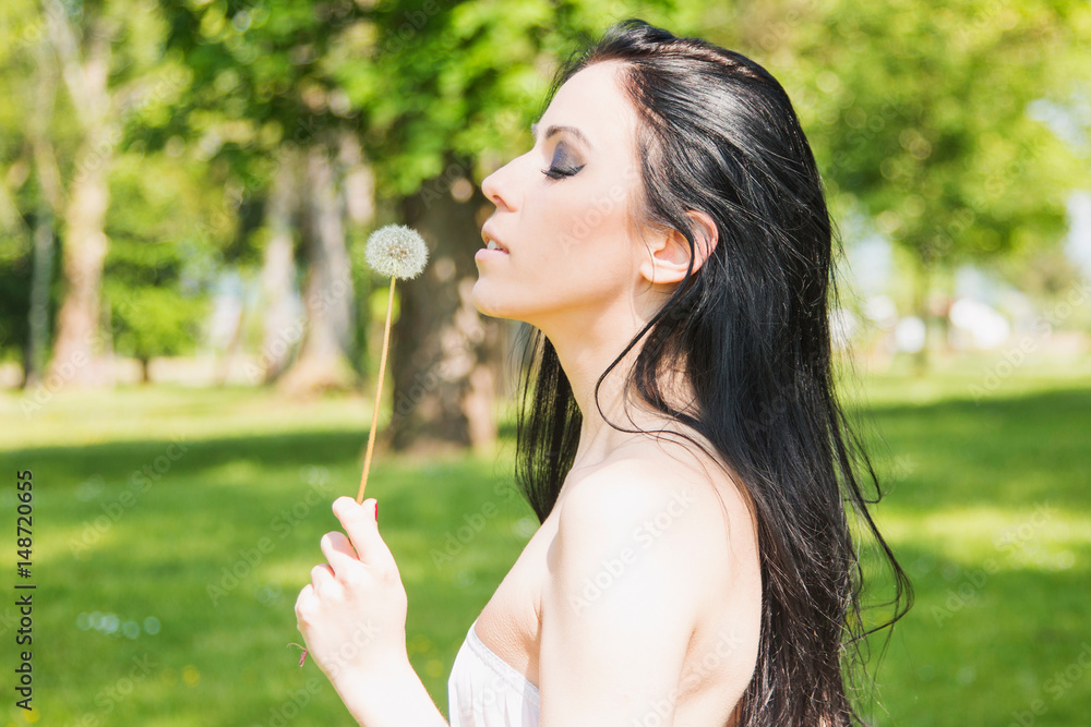 Beautiful black hair girl with dandelion in hand in nature Beautiful black hair girl with dandelion in hand in nature