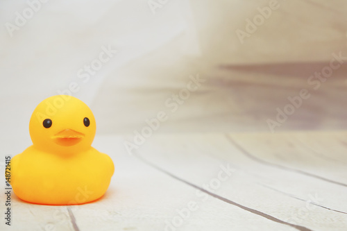 yellow duck toys over wooden table backgrounds