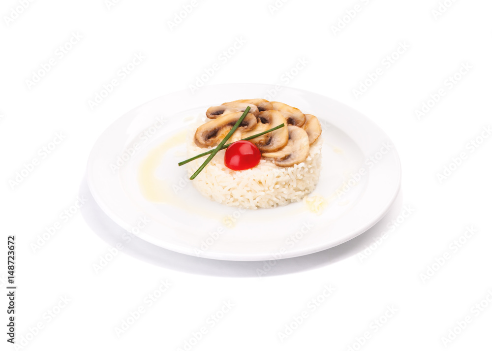 White rice dish with mushrooms and a tomato, on a plate isolated on a white background. Decorated by lettuce.