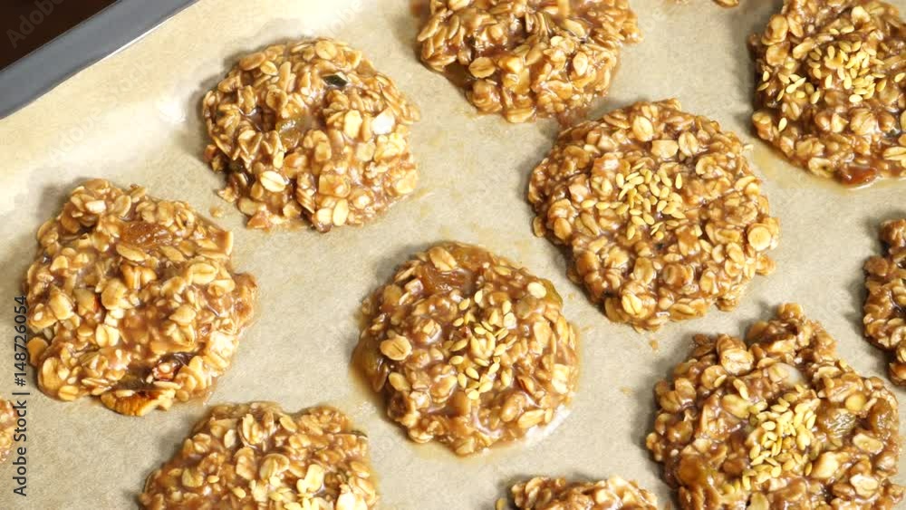 Food background. Nobody. Homemade oatmeal cookies on baking tray ready to be baked. Dolly sliding shot 4K ProRes HQ codec Food background. Nobody. Homemade oatmeal cookies on baking tray ready to be baked. Dolly sliding shot 4K ProRes HQ codec