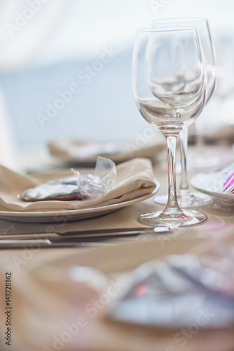 Sparkling wineglasses stand on dinner table before a plate