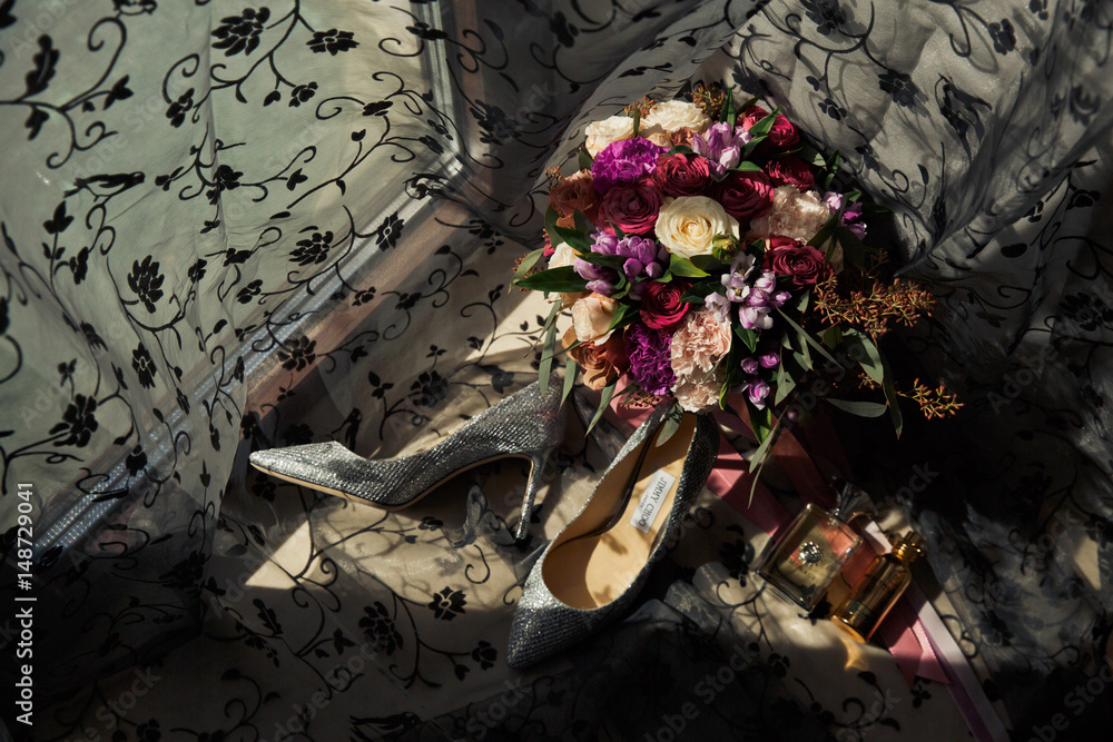 Look from above at colorful wedding bouquet, shoes and rings on the windowsill