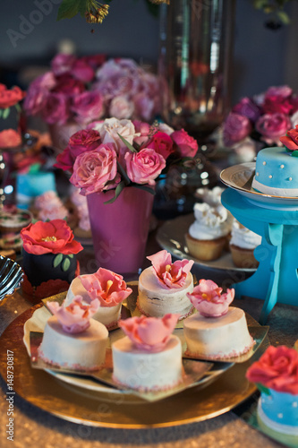 Plate with white cakes and pink roses made of icing