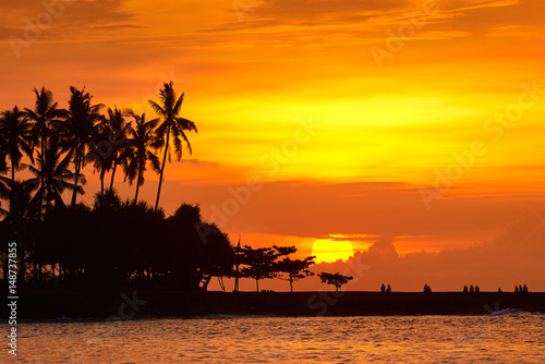 People are looking beautiful sunset on tropical beach of Senggigi island Lombok, Indonesia.