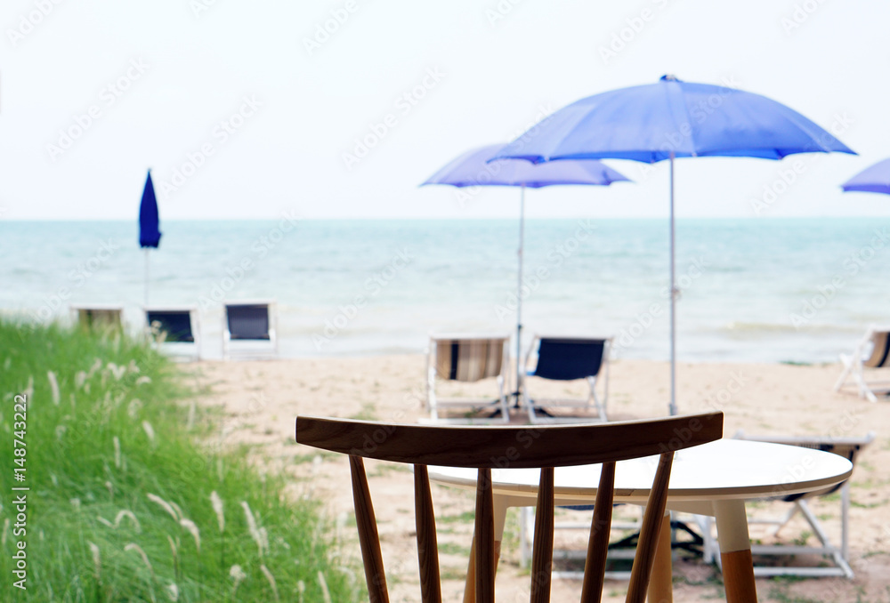 The summer holiday for sunshine in Pattaya, Beach lounge chairs under Outdoor Umbrella on the beach, meadow and sea view background.