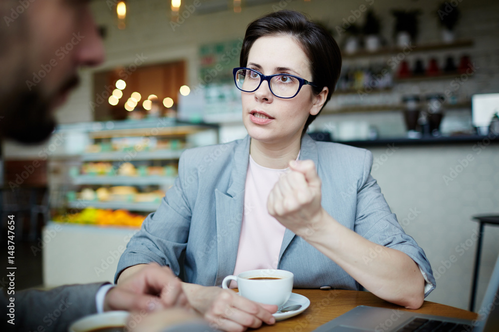 Serious economist explaining her colleague something important Serious economist explaining her colleague something important