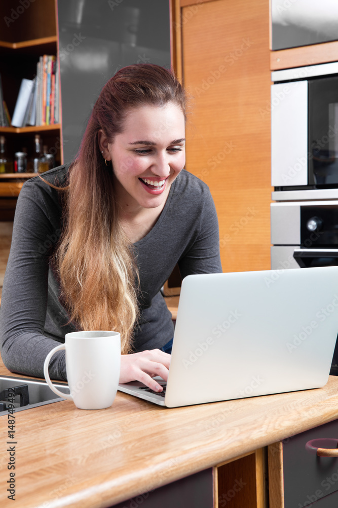 laughing young woman with computer to telecommute or buy online laughing young woman with computer to telecommute or buy online