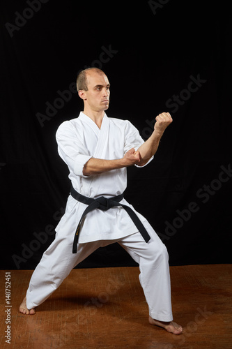 With a black belt, an athlete trains karate blocks
