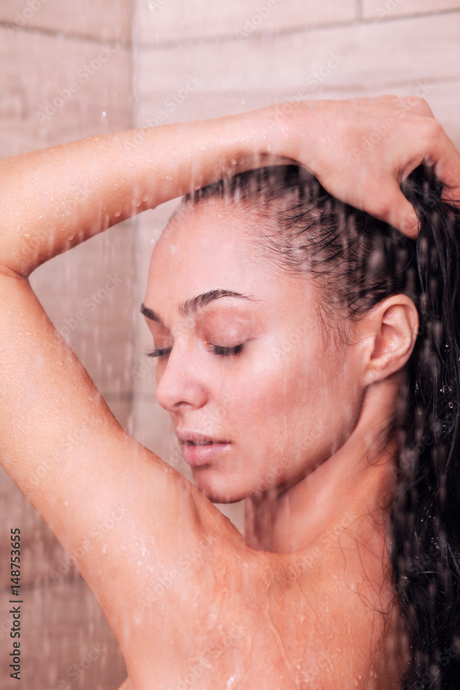 Naklejka premium Young beautyful woman under shower in bathroom