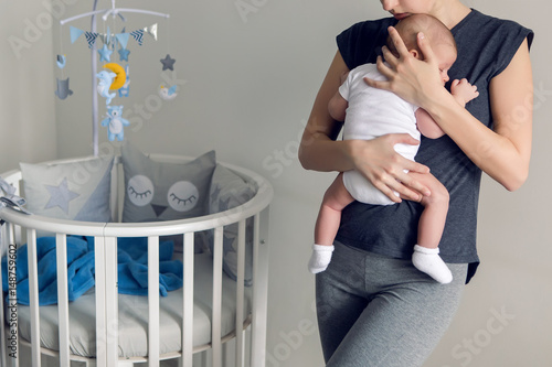 Obraz na plátně mother sleeping on the chest of his son is at round bassinet at home