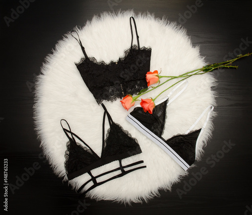 Print op canvas Fashionable concept, three black lace bodices on white fur, orange roses, top vi