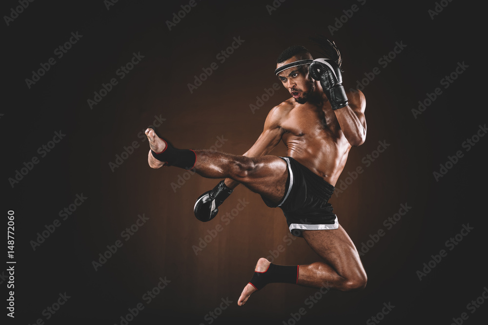 Side View Of Angry Trainign Muay Thai Fighter In Boxing Gloves, Action 