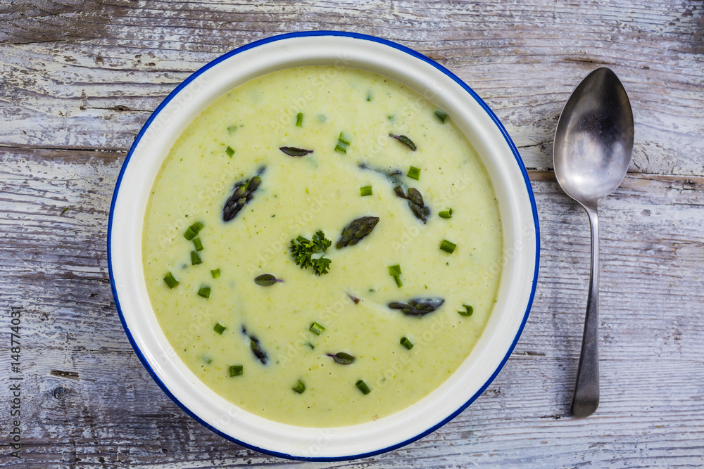 Delicious creamy asparagus soup on a wooden background. Delicious creamy asparagus soup on a wooden background.