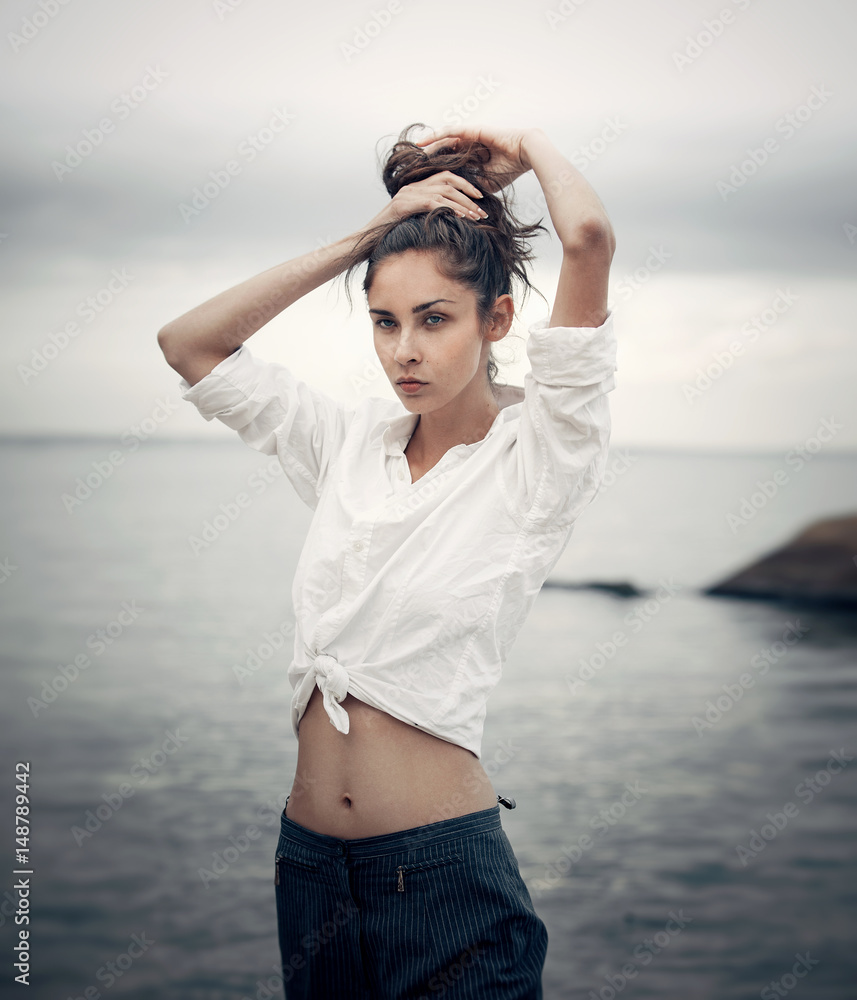 woman in white clothing fixes hair. woman in white clothing fixes hair.